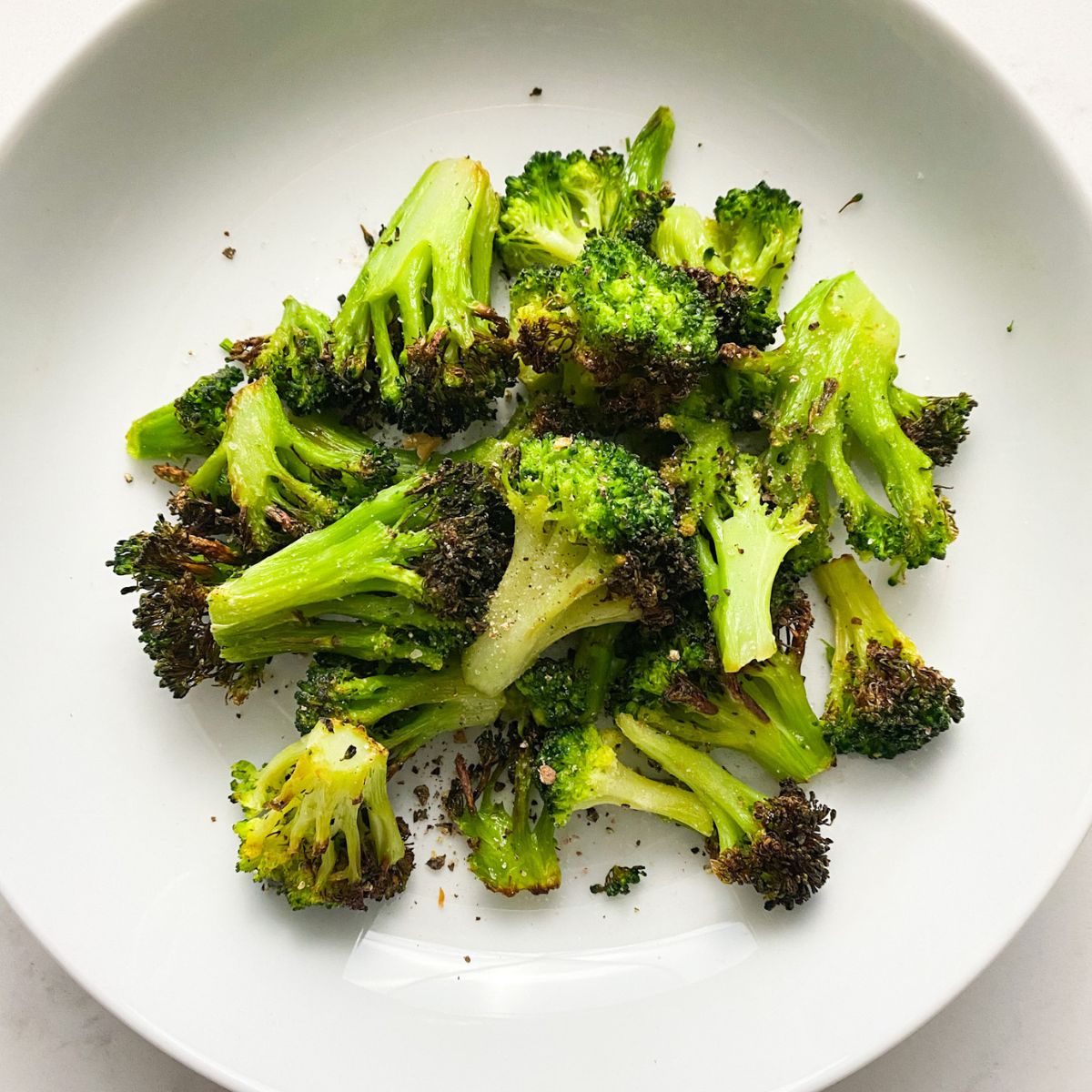 air fried broccoli on a white plate