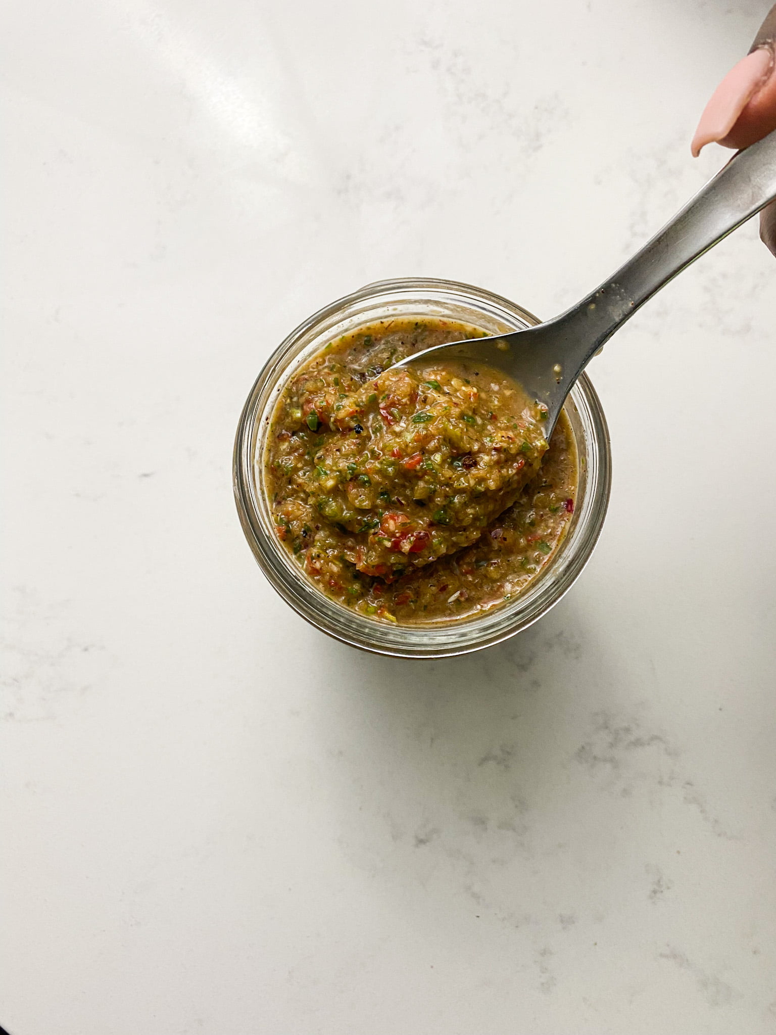paleo chicken marinade in a jar with a silver spoon